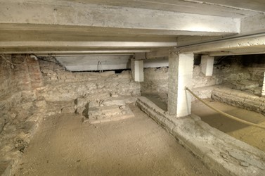 <p>Overzicht van de bewaarde gebleven funderingsresten van de crypt uit de 10e eeuw in de richting van het schip van de kerk. Op de voorgrond het fundament van de trap die behoorde bij de zuidelijke doorgang vanuit de kerk. </p>

